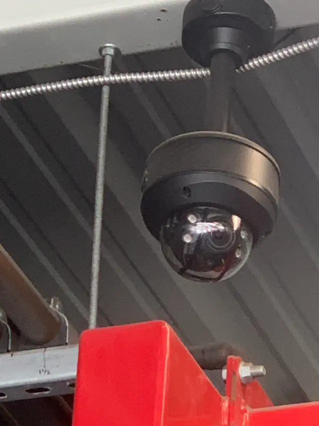 Dome security camera mounted under a commercial building eave
