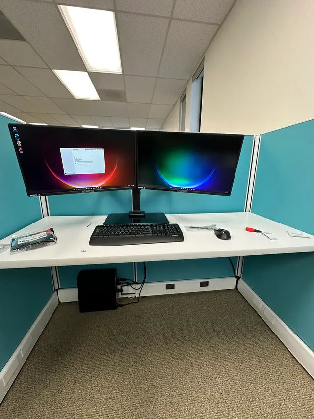 Dual monitors on an articulating arm installed at an office cubicle