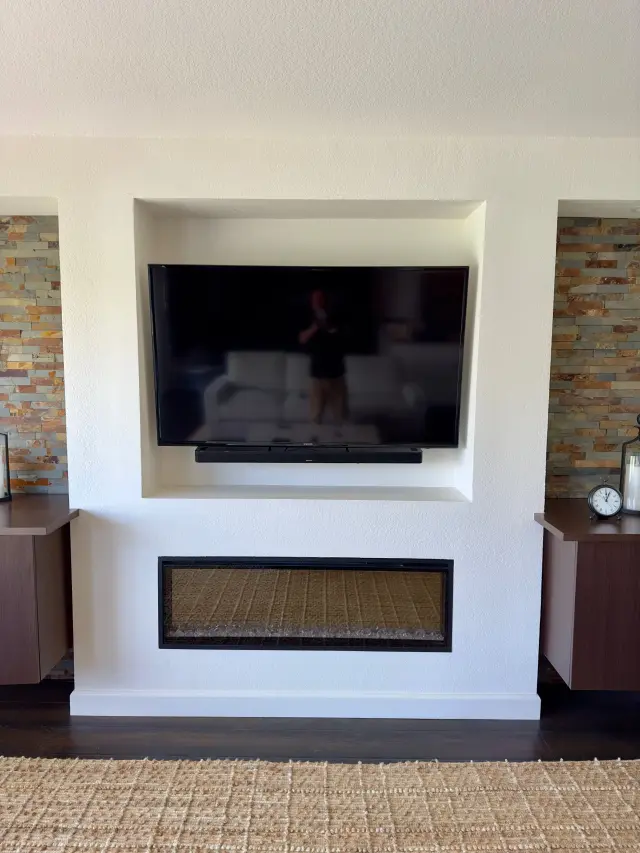Fireplace television and soundbar installation with concealed wiring and clean finish