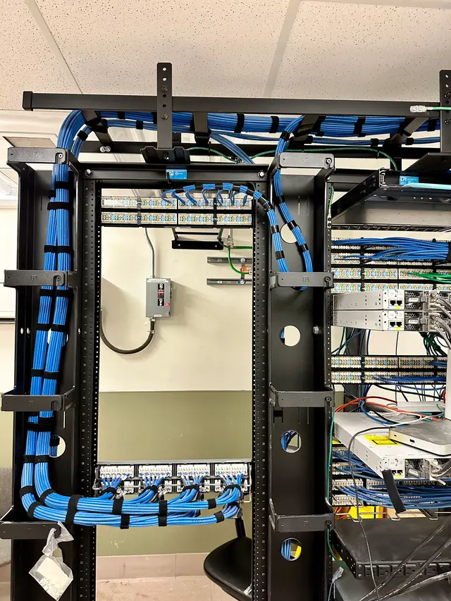 Floor-standing rack with vertical cable management and blue Cat6 runs