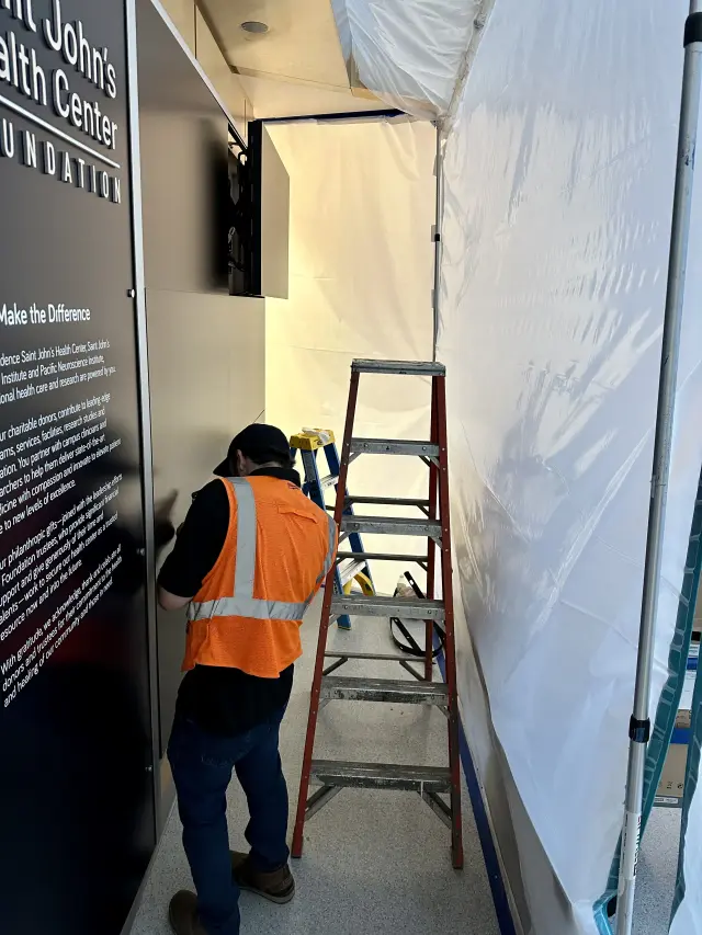 Technician installing commercial video wall system in healthcare facility during construction